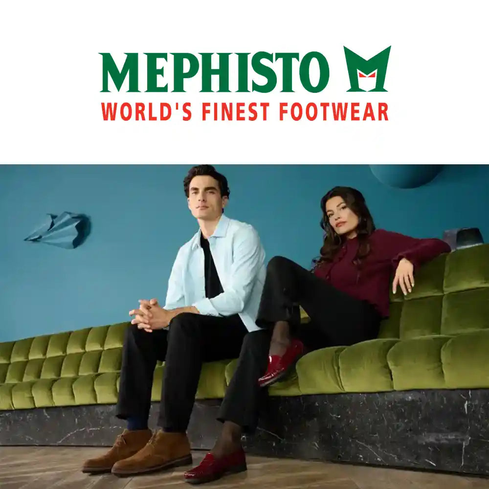 Two people sitting on a green couch with Mephisto logo above them.